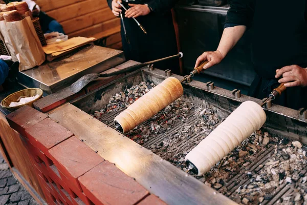 Comida de rua no mercado de Natal em Budapeste, Hungria - Kurtoskalacs, a pastelaria clássica nacional, também chamada - Baumkuchen, Trdelnik, Shakotis . — Fotografia de Stock