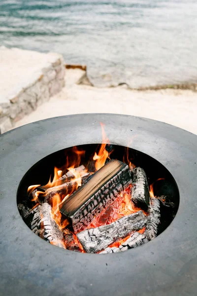 Yuvarlak kızartma yüzeyine yakın çekim, içinde yanan odun var.. 