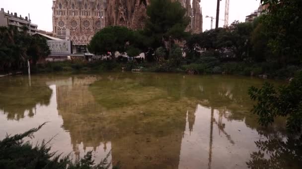 A fachada do Natal da Sagrada Família, uma vista da igreja do parque. Guindastes de construção estão construindo o edifício . — Vídeo de Stock