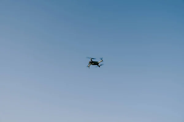 Szary mały dron lata na niebieskim niebie. — Zdjęcie stockowe