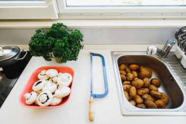 Masada taze mantarlar, kıvırcık maydanoz, mutfak lavabosunda soyulmuş patates değil..
