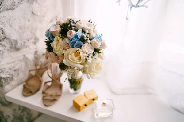 Ramo nupcial de rosas blancas y rosadas, babys respiran, scabiosa, cintas hortense y blancas en una abertura de ventana de ladrillo y zapatos de la novia y perfume cerca de ella —  Fotos de Stock