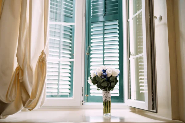 Ramo nupcial de tulipanes blancos, delphinium, salal, limonium y cintas de encaje en jarrón de vidrio en el alféizar de la ventana —  Fotos de Stock