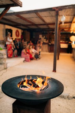 Çember şekilli ızgara masası. Kumsalda, çardağın yanında..