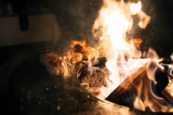 Les steaks sont grillés dans les flammes du feu. — Photo