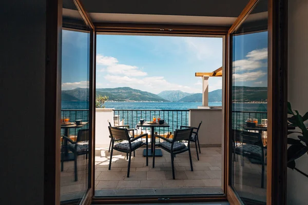 Vista do apartamento no mar. Varanda com mobiliário de jardim e pequeno-almoço na mesa. Croissants e suco de laranja espremido na hora . — Fotografia de Stock