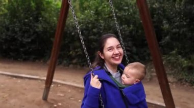 Anne ve bebek salıncakta sallanıyor..