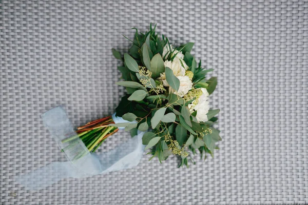 Bouquet nuptial de pivoines blanches, branches d'olivier et d'eucalyptus, rubans blancs sur fond tressé — Photo