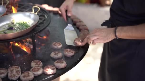 Szef kuchni grilluje klopsiki do mini hamburgerów na grillu. — Wideo stockowe