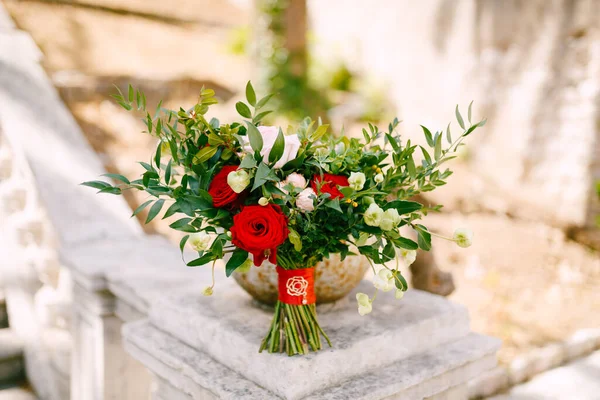 Buket pengantin mawar merah dan merah muda, cabang boxwood, tidak mekar tunas bunga putih dan pita merah dengan broochon pagar tangga kuno — Stok Foto