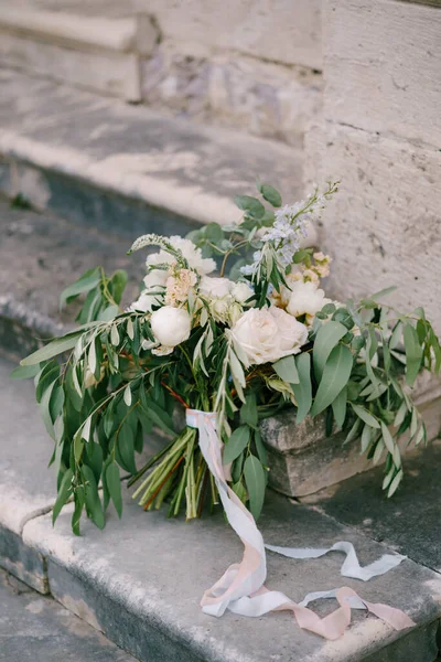 Ramo nupcial de peonías blancas y crema, rosas, verónica, ramas de eucalipto con cinta blanca en la antigua escalera —  Fotos de Stock