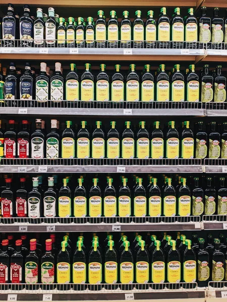 Podgorica, Montenegro - 02 de julio de 2020: Estantes de supermercado con botellas de aceite de oliva . — Foto de Stock