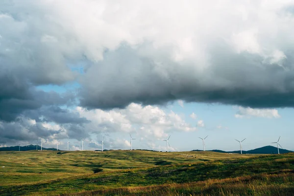 Panorama of many huge wind turbines on the horizon line with blue sky with clouds. Green technology concept. Industrial wind farm in northern Montenegro. — Stock Photo, Image