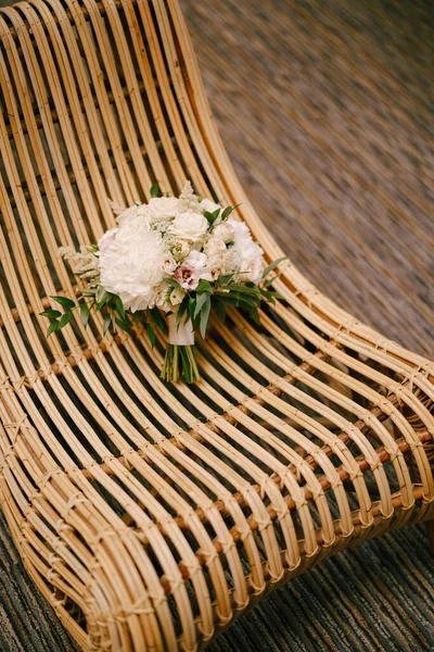 흰 완두콩, 장미, 분홍빛 우구아, 관목, 짚으로 만든 의자에 달린 유칼립투스 나무의 가지들로 만든 신부용 부케 — 스톡 사진