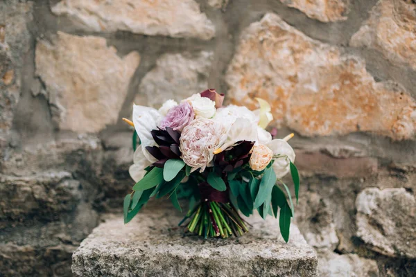 Buquê nupcial de peônias brancas e rosa, rosas, ramos de eucalipto, lírios calla e alcachofra decorativa na pedra — Fotografia de Stock