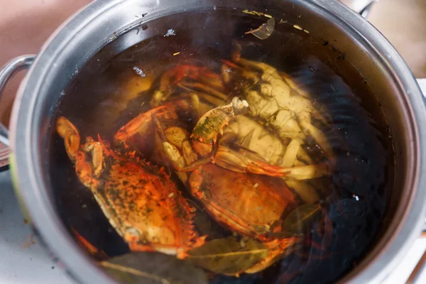 Caranguejos azuis cozidos vermelhos em água fervente com temperos . — Fotografia de Stock