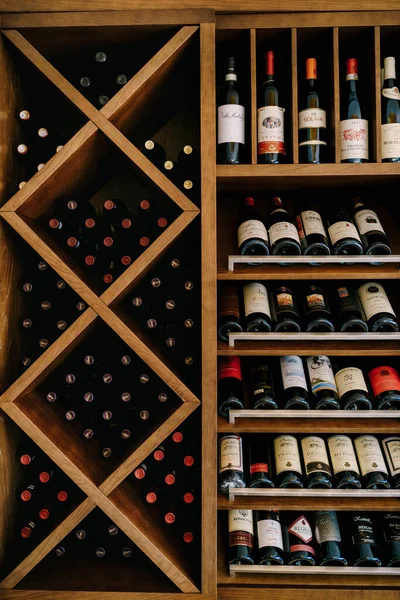 Budva, Montenegro - 05 de junho de 2020: Um armário de vinho de madeira com garrafas de vinho . — Fotografia de Stock