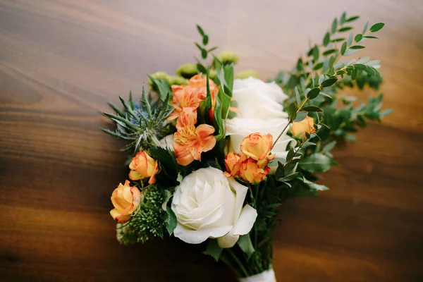 Ramo nupcial de rosas blancas y naranjas, eringyum, ammi, ramas de boj, alstroemeria con cintas blancas en el suelo —  Fotos de Stock