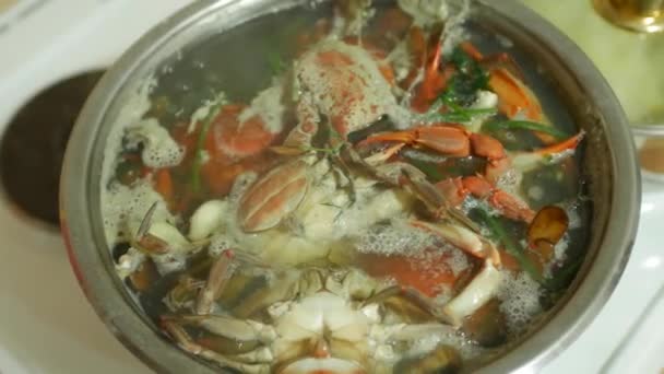 Red mites stick out of boiling water in a saucepan. Blue crabs - a delicacy of seafood is prepared in the kitchen. — Stock Video