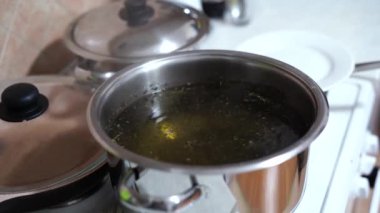 Sobanın üstündeki tencerede baharatlı kaynar su. Deniz ürünleri pişirmek için su hazırlanıyor..