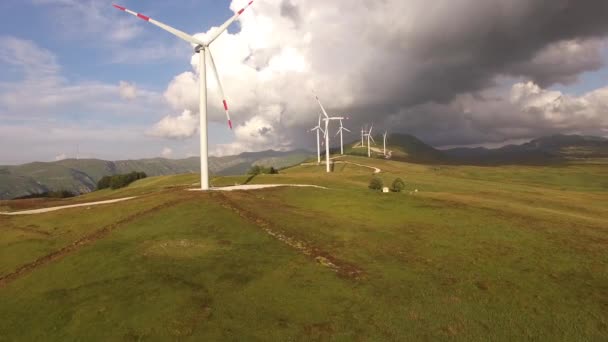 Muchos aerogeneradores en la colina, contra el telón de fondo de un cielo épico . — Vídeos de Stock