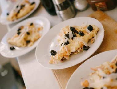 Peynirli yumurta omleti ve beyaz tabakta siyah zeytin..