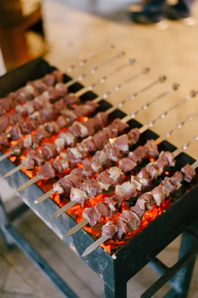 Barbacoa en la parrilla. Shashlik hecho de cubos de carne en los pinchos durante la cocción en el mangal sobre carbón al aire libre —  Fotos de Stock