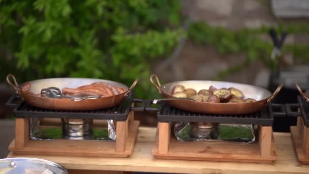 Tre padelle per il catering. Buffet con salsicce, patate fritte e pomodori alla griglia. — Video Stock