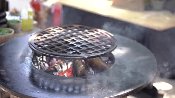 Ronde grill met plat roosteren. Ronde grille in het midden met een vuur. — Stockvideo