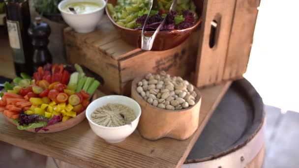 Bufetový stůl na cateringu je velký talíř s pistáciemi, omáčkami, saláty a zeleninovými plátky. — Stock video