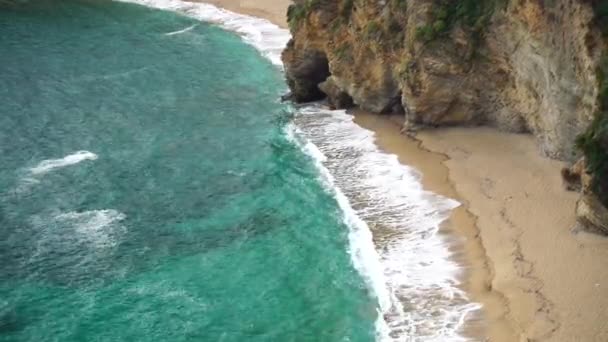 Mogren Beach près de la vieille ville de Budva, au Monténégro. Une plage déserte de sable fin paradisiaque avec de l'eau azur et des vagues bleues. vue de la montagne — Video