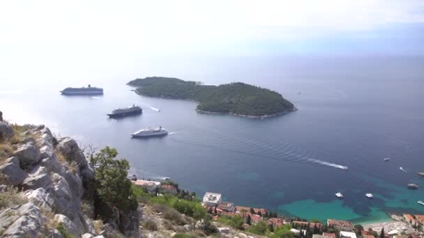 Lokrum é uma pequena ilha no Mar Adriático, perto de Dubrovnik, Croácia. Um pequeno navio de cruzeiro atracado perto da ilha. Vista do deck de observação da montanha acima de Dubrovnik . — Vídeo de Stock