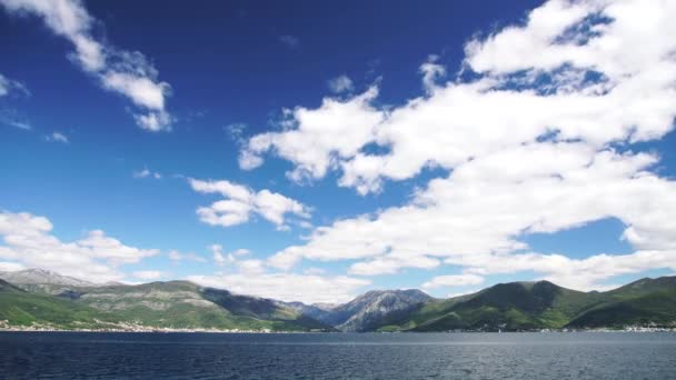 Blauer Himmel mit schneeweißen Wolken über dem Golf von Kotor in Montenegro. — Stockvideo