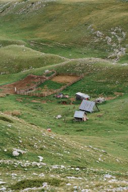 Karadağ dağları arasında, Durmitor ulusal parkında, Zabljak 'taki yeşil tepelerde boş bir koyun ağılı..