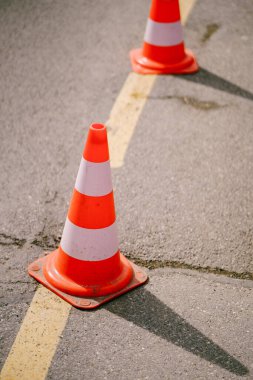 Turuncu trafik konileri asfaltta sıralanmış, yakın plan..