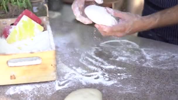 Chefs handen van dichtbij. Bereid het deeg voor pizza, rolt uit in ronde vormen met zijn handen. — Stockvideo