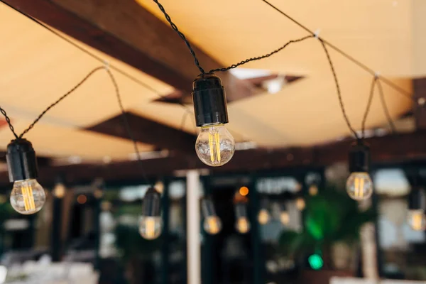 Garlands av LED-lampor över ett bankettbord för en bröllopsmiddag. — Stockfoto