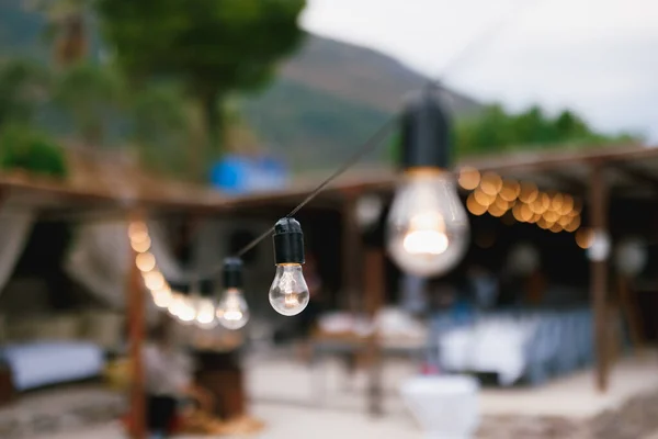 En närbild av en glödlampa i en krans på stranden. — Stockfoto