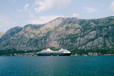 Karadağ 'ın Dovrota ve Ljuta kentinin yukarısındaki bir dağın zeminine karşı Kotor Körfezi' nde çok katlı dev bir yolcu gemisi..