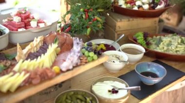 Peynir, sosis dilimleme, sosis, salata ve sebze dilimleme ile büfe masası. Oteldeki ahşap masa tamamen kapsayıcı.. 