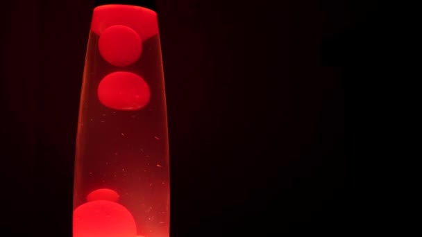 Unika mönster som bildas av det varma vaxet som rör sig inuti en röd lavalampa — Stockvideo