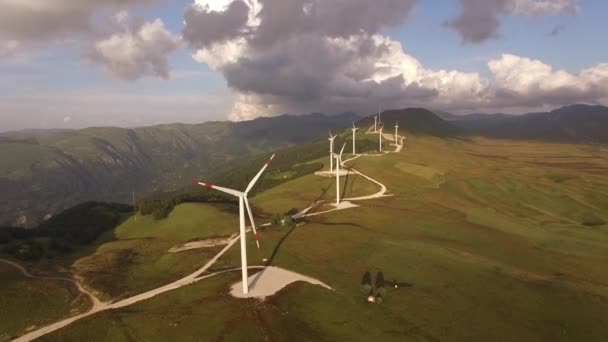 Turbinas eólicas en un campo amarillo con cielos azules y nubes blancas . — Vídeo de stock