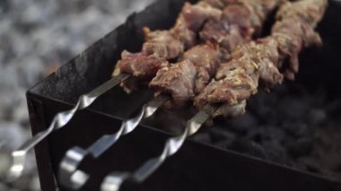 Bahçe ızgarasında lezzetli şişler. Et bir tükürüğe delindi ve mangal kömürüyle kızartıldı. Izgara ızgara. Shashlik. Seçici odaklanma. Yumuşak odak