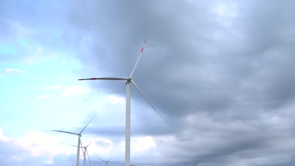 Un primo piano delle pale dell'enorme turbina eolica lavata contro il cielo. — Video Stock