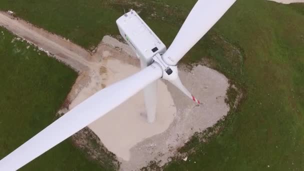 Detailní záběr lopatek větrných turbín s červenými pruhy proti zelenému lesu a poli. — Stock video