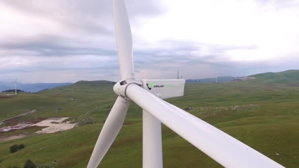 Detailní záběr lopatek větrných turbín s červenými pruhy proti zelenému lesu a poli. — Stock video