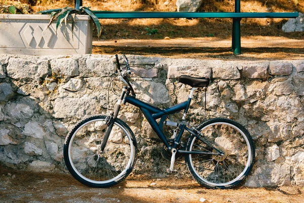 Bicicleta azul junto al bordillo de piedra en la calle — Foto de Stock