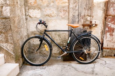 Köpük bloklardan bir duvara karşı bisiklet ve metal cıvatalı ahşap bir kapı