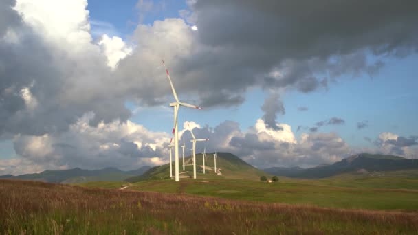 Enormi turbine eoliche sulla collina accanto al condominio. — Video Stock