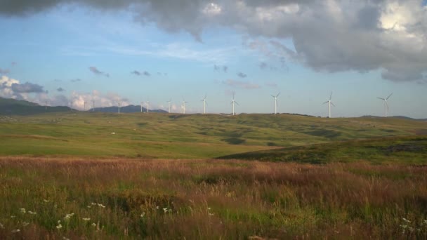 Un certo numero di turbine eoliche su verdi colline sulle montagne del Montenegro, contro il cielo nuvoloso piovoso. — Video Stock